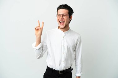 Beyaz arka planda izole edilmiş Rus işadamı gülümsüyor ve zafer işareti gösteriyor.