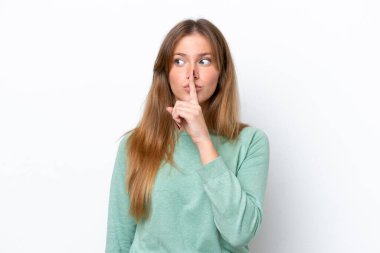 Beyaz arka planda izole edilmiş beyaz bir kadın sessiz bir jest işareti gösteriyor. Parmağını ağzına sokuyor.