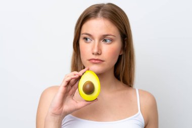 Beyaz arka planda avakado tutan beyaz bir kadın. Portreyi kapat