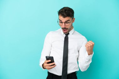 Mavi arka planda izole edilmiş beyaz bir adam şaşırdı ve bir mesaj gönderiyor.