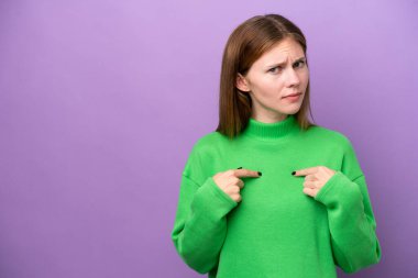 Mor arka planda izole edilmiş genç bir İngiliz kadın kendini işaret ediyor.
