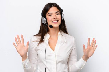 Beyaz arka planda izole edilmiş bir kulaklıkla çalışan beyaz pazarlamacı kadın parmaklarıyla 10 kişi sayıyor.