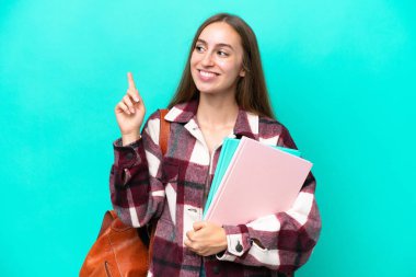 Young student caucasian woman isolated on blue background pointing up a great idea