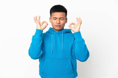 Genç Ekvadorlu adam Zen pozunda beyaz arka planda izole edilmiş.