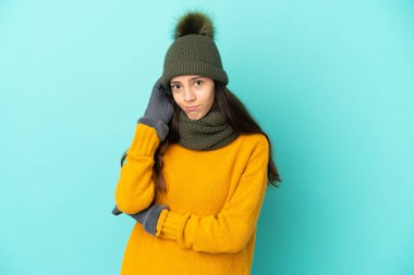 Mavi arka planda izole edilmiş genç bir Fransız kız, kış şapkası kuşkulu.