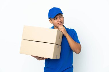Teslimat yapan Ekvadorlu adam beyaz arka planda izole edilmiş, yana bakıyor ve gülümsüyor.