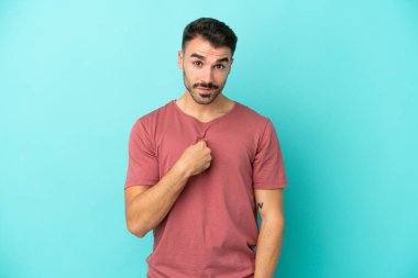 Mavi arka planda yalıtılmış beyaz bir adam. Şaşırtıcı bir yüz ifadesi var.