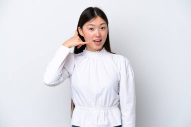 Beyaz arka planda izole edilmiş genç Çinli bir kadın telefon jesti yapıyor. Bana geri dönüş işareti ver.