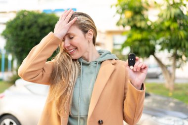 Dışarıda arabanın anahtarlarını tutan genç sarışın kadın bir şey fark etti ve çözümü arıyor.