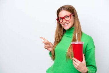 Beyaz arka planda izole edilmiş soda içen beyaz tenli genç bir kadın...