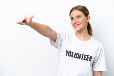 Beyaz arka planda izole edilmiş genç gönüllü bir kadın baş parmak işareti yapıyor.