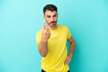 Genç beyaz adam mavi arka planda izole edilmiş bir şekilde geliyor.