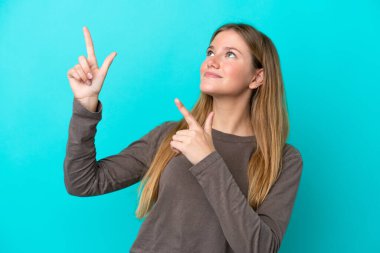 Mavi arka planda izole edilmiş genç sarışın kadın işaret parmağıyla işaret etmek harika bir fikir.