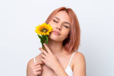 Beyaz arka planda izole edilmiş genç bir Rus kızı elinde bir ayçiçeği tutuyor. Portreyi kapat