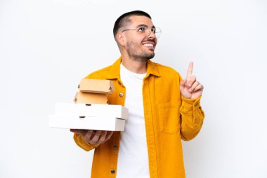 Arka planda pizza ve hamburger tutan beyaz bir adam harika bir fikre işaret ediyor.