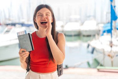 Genç, güzel Ukraynalı bir kadın elinde pasaport ağızları açık bağırıyor.