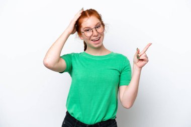 Beyaz arka planda izole edilmiş genç, kırmızı bir kadın. Şaşırmış ve işaret ediyor.