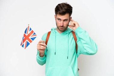 Beyaz arka planda izole edilmiş bir Birleşik Krallık bayrağı taşıyan beyaz bir öğrenci hayal kırıklığına uğramış ve kulaklarını kapatmış.