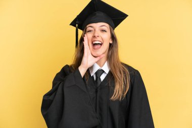 Sarı arka planda ağzı açık bağıran genç üniversite mezunu.