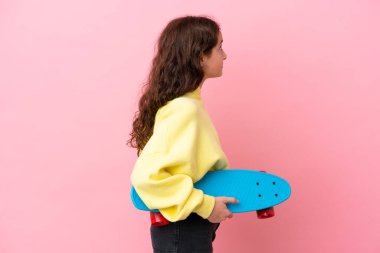 Pembe arka planda paten kayan beyaz bir kız.