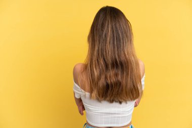 Sarı arka planda izole edilmiş genç beyaz kadın.