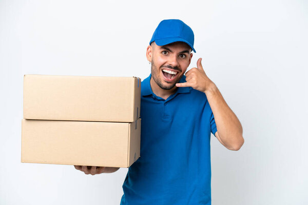 Delivery caucasian man isolated on white background making phone gesture. Call me back sign