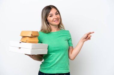 Genç Romen kadın elinde fast-food tutuyor beyaz arka planda izole edilmiş bir şekilde parmak kaldırıyor