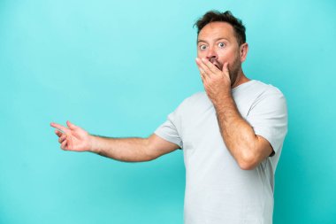 Orta yaşlı, beyaz, mavi arka planda izole edilmiş bir adam.