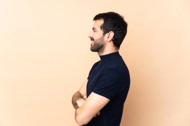 Kafkasyalı yakışıklı adam, soyutlanmış arka planda yan pozisyonda.