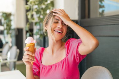 Açık havada kornet dondurmalı genç sarışın kadın bir şey fark etti ve çözümü arıyor.