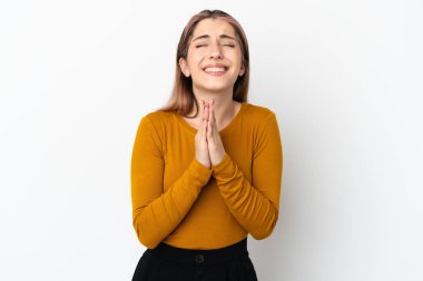 Beyaz arka planda izole edilmiş genç beyaz kadın avuç içlerini bir arada tutuyor. İnsan bir şey ister.