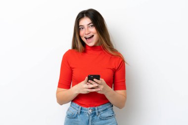 Beyaz arka planda izole genç beyaz kadın şaşırdı ve bir mesaj gönderiyor.