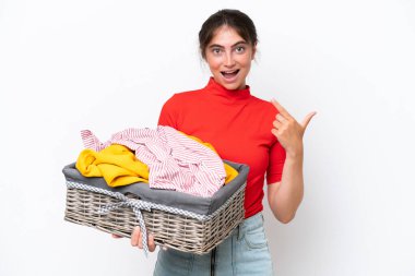 Beyaz arka planda izole edilmiş çamaşır sepetini tutan beyaz bir kadın baş parmak işareti yapıyor.