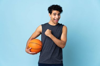 Venezuelalı basketbolcu izole bir arka planda zaferi kutluyor.