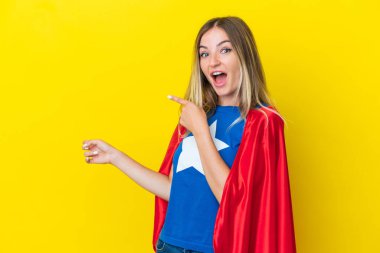 Sarı arka planda izole edilmiş Süper Kahraman Romen kadın şaşırmış ve işaret ediyor