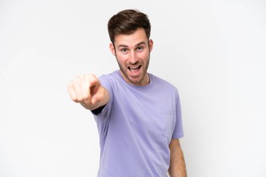 Beyaz arka planda izole edilmiş genç beyaz adam hayal kırıklığına uğramış ve ön tarafı işaret ediyor.