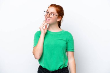 Beyaz arka planda izole edilmiş genç bir kadın gülümserken yukarı bakıyor.