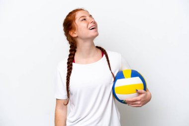 Beyaz arka planda izole bir şekilde voleybol oynayan beyaz tenli genç kadın kahkaha atıyor.