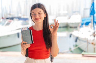 Genç, güzel Ukraynalı kadın elinde pasaport tutarken parmaklarıyla 