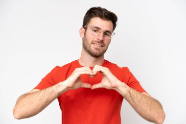Beyaz arka planda izole edilmiş, gözlüklü, elleriyle kalp yapan beyaz bir adam.