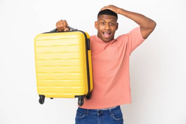 Beyaz arka planda izole edilmiş, seyahat valiziyle gezen genç bir Latin.
