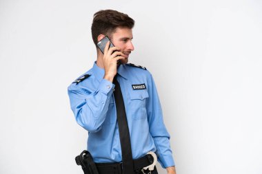 Beyaz arka planda izole edilmiş genç bir beyaz adam cep telefonuyla sohbet ediyor.