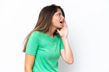 Beyaz arka planda izole edilmiş genç beyaz kadın ağzı sonuna kadar açık bağırıyor.