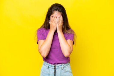 Sarı arka planda izole edilmiş, yorgun ve hasta bir ifadeyle genç beyaz bir kadın.