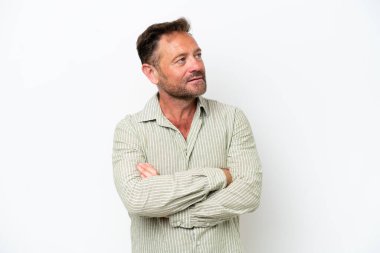 Beyaz arka planda izole edilmiş orta yaşlı beyaz bir adam yan tarafa bakıyor.