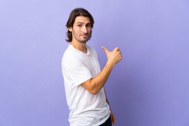 Mor arka planda soyutlanmış, gururlu ve kendini beğenmiş genç bir adam.