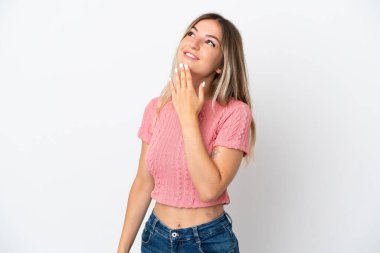 Genç Romen kadın beyaz arka planda izole edilmiş gülümserken yukarı bakıyor