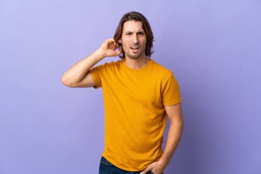 Mor arka planda izole edilmiş genç yakışıklı adamın şüpheleri var.