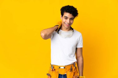 Venezuelalı elektrikçi, sarı arka planda izole edilmiş gülüyor.