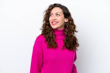 Beyaz arka planda izole edilmiş genç beyaz kadın yukarı bakarken bir fikir düşünüyor.